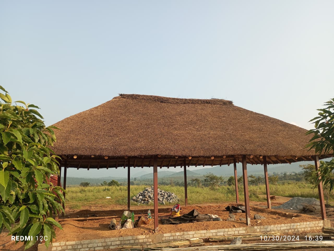 Coconut leaf thatching being installed on a roof by craftsmen